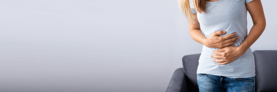 Female holding stomach with both hands for stomach ache