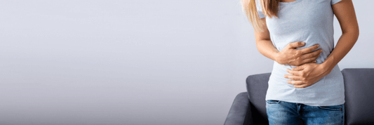 Female holding stomach with both hands for stomach ache