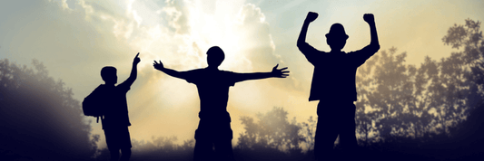 Three silhouettes of men standing in the sunrise
