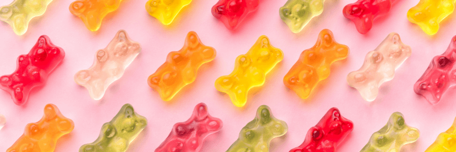 pink background, red, clear, yellow, and orange gummy bears