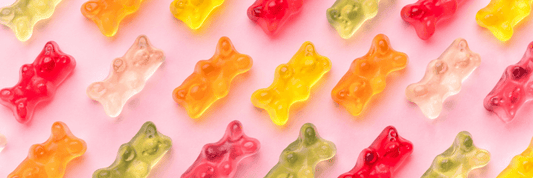 pink background, red, clear, yellow, and orange gummy bears