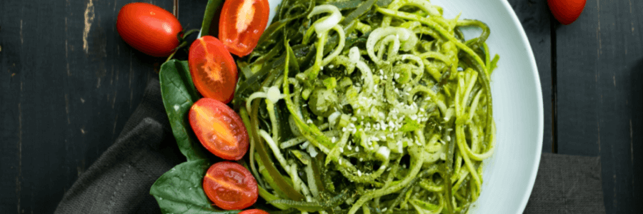 Linguini pasta in a green sauce on white plate
