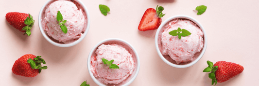 3 cups pink strawberry ice cream, pink background, sliced strawberries surrounding