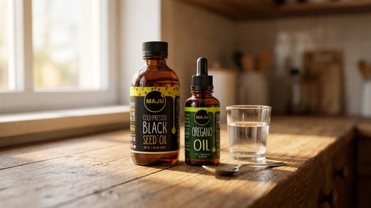 MAJU black seed oil and oregano oil bottles together on a kitchen counter