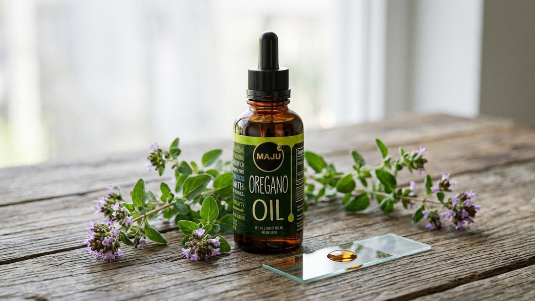 Fresh wild oregano sprigs around a MAJU oregano oil dropper bottle